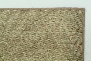 This tan rug is made of natural fiber and is finished at 72"x48" with a narrow cotton binding