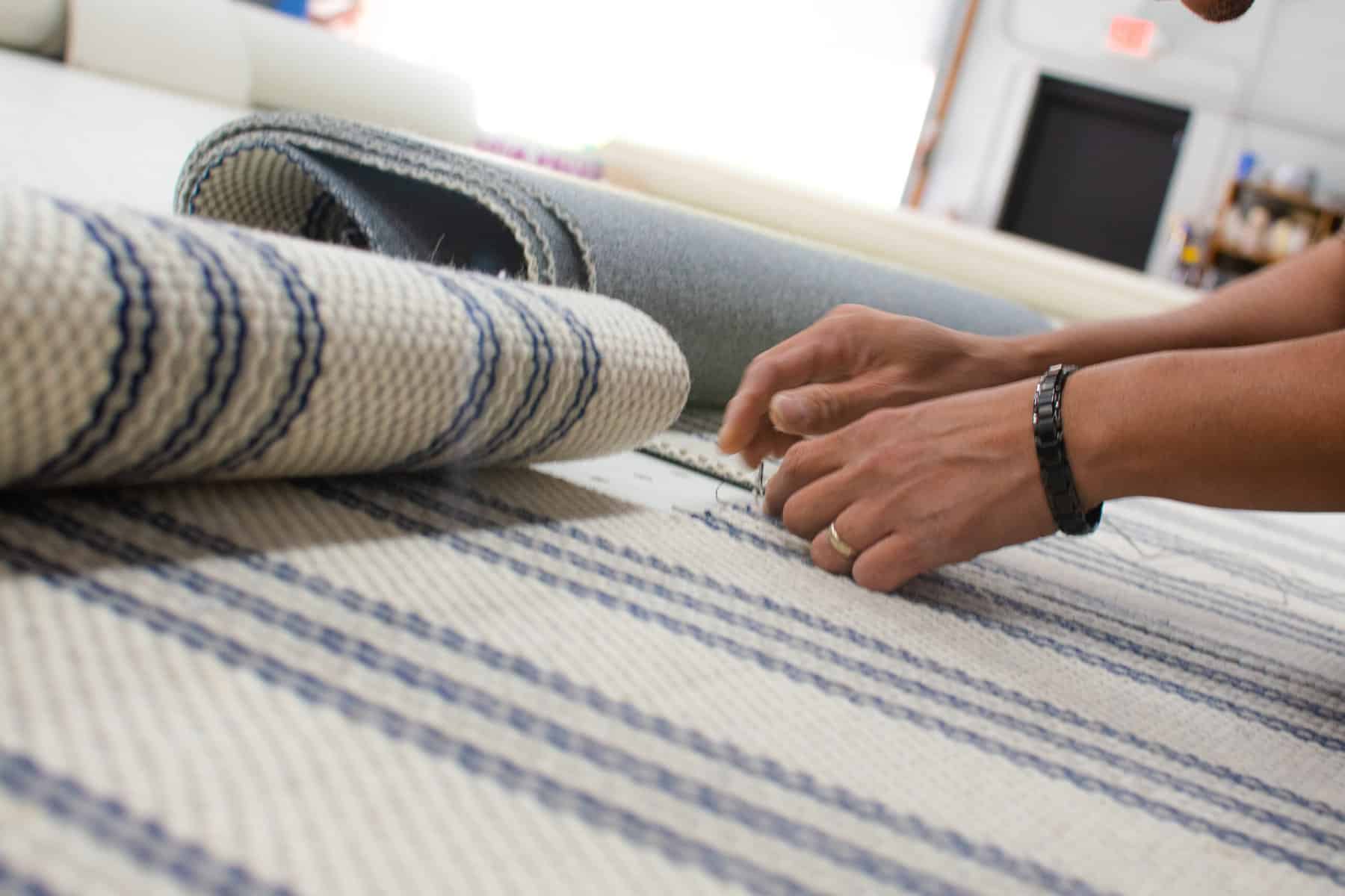 Fabricator hand stitching a custom stair runner project.