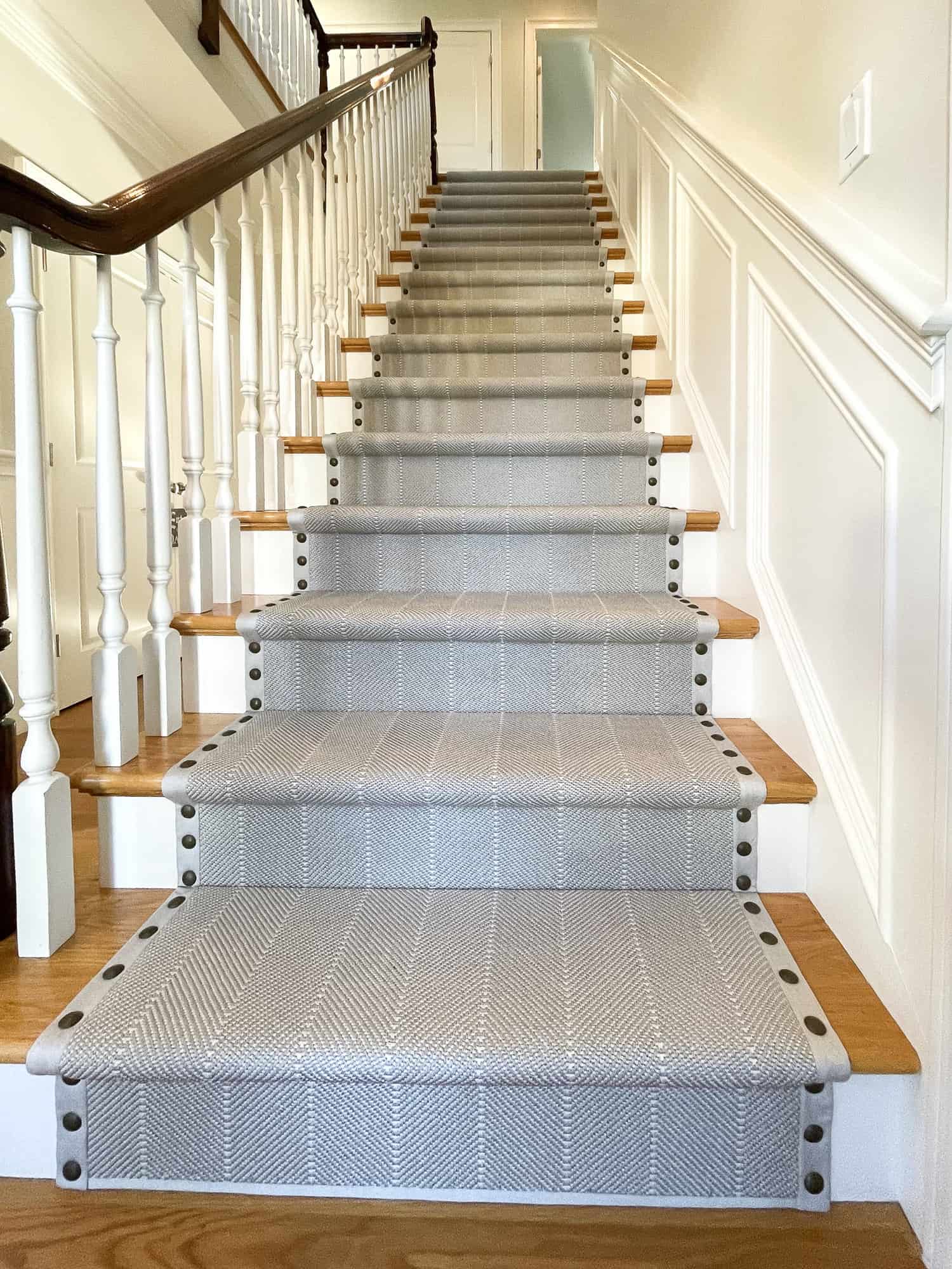This is a grey with white stripe carpet hollywood cheveron style stair runner with grey wide binding with details ensures that the carpet contours the stairs from top to bottom.