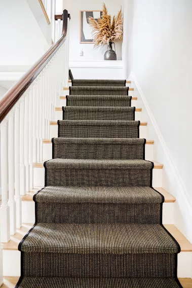 Black and cream striped carpet that is fabricated and installed as a stair runner.