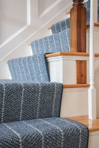 This is a navy blue and white striped carpet herringbone style that is fabricated and installed as a stair runner.