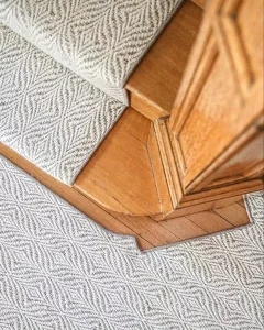 Carpet with a diamond pattern style grey and white colors fabricated and installed as a stair runner.