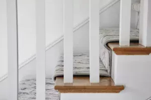 Side view of installed stair runner carpet with narrow binding neutral colors by The carpet Workroom.