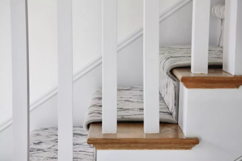 Side view of installed stair runner carpet with narrow binding neutral colors by The carpet Workroom.