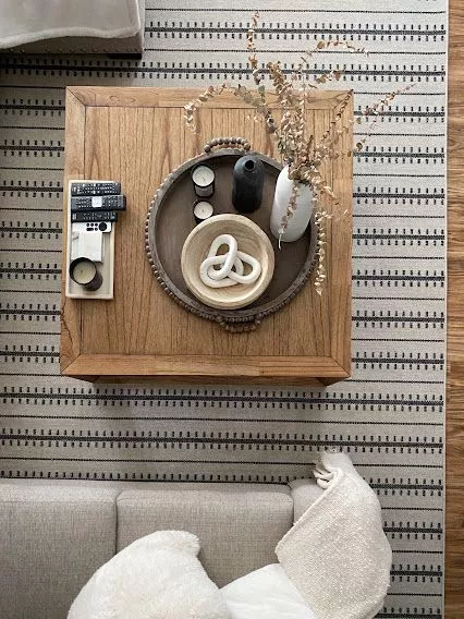 Living room with neutral colors styled with a rug made by The carpet workroom.