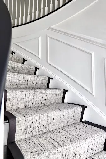 Black and white textured carpet finished with a wide black binding fabricated and installed as a stair runner.