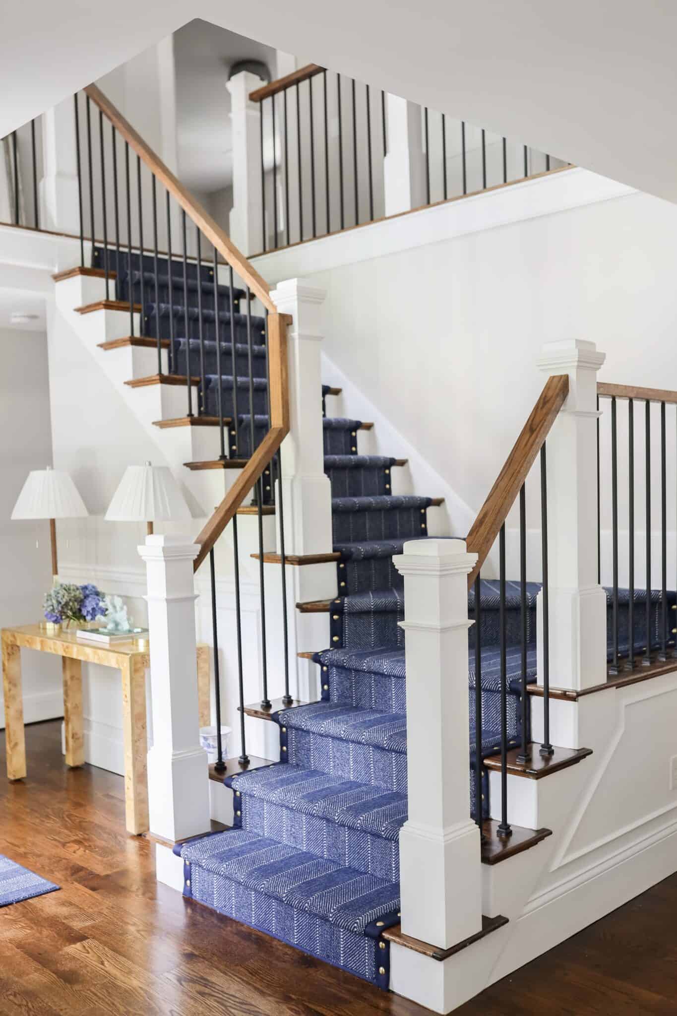 This is a navy blue with white stripe carpet hollywood cheveron style stair runner with blue wide binding with details ensures that the carpet contours the stairs from top to bottom.