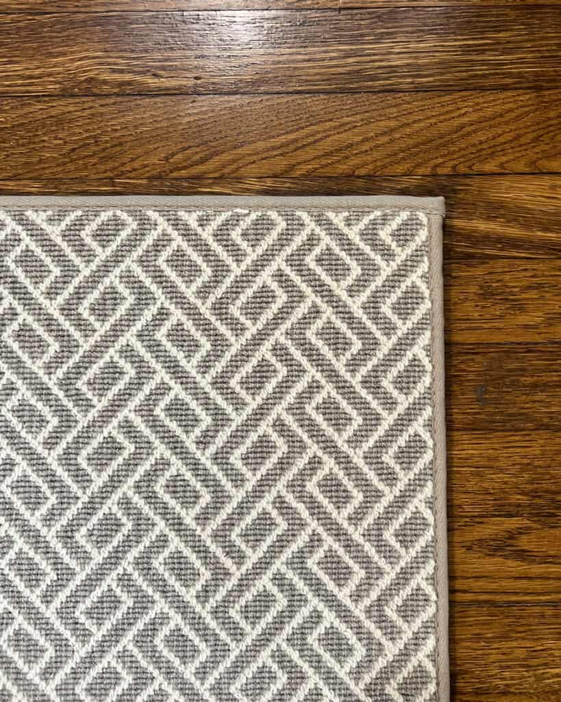 Grey and white geometric patterned wool rug with narrow binding 