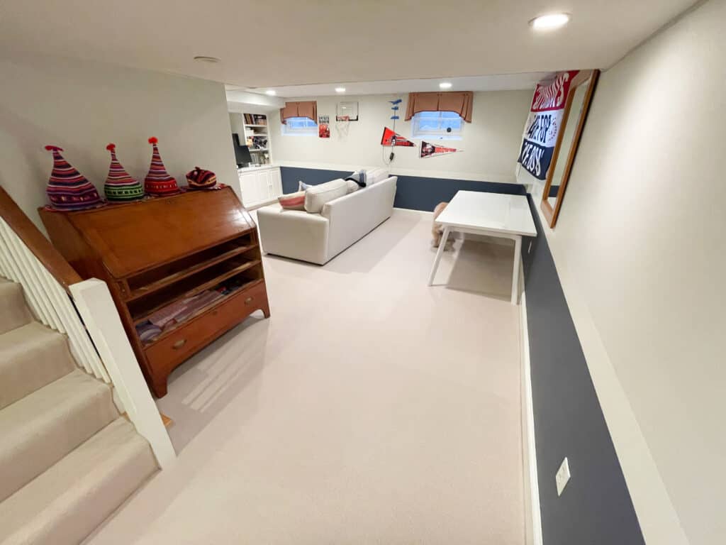 Wall to wall carpet installation in basement family room. Light colored wool rug with white/blue walls