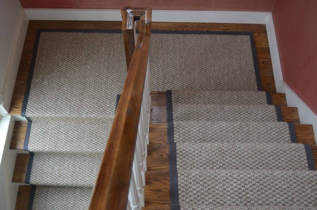 Sisal Stair runner with wide binding on a large set of stairs with a landing.