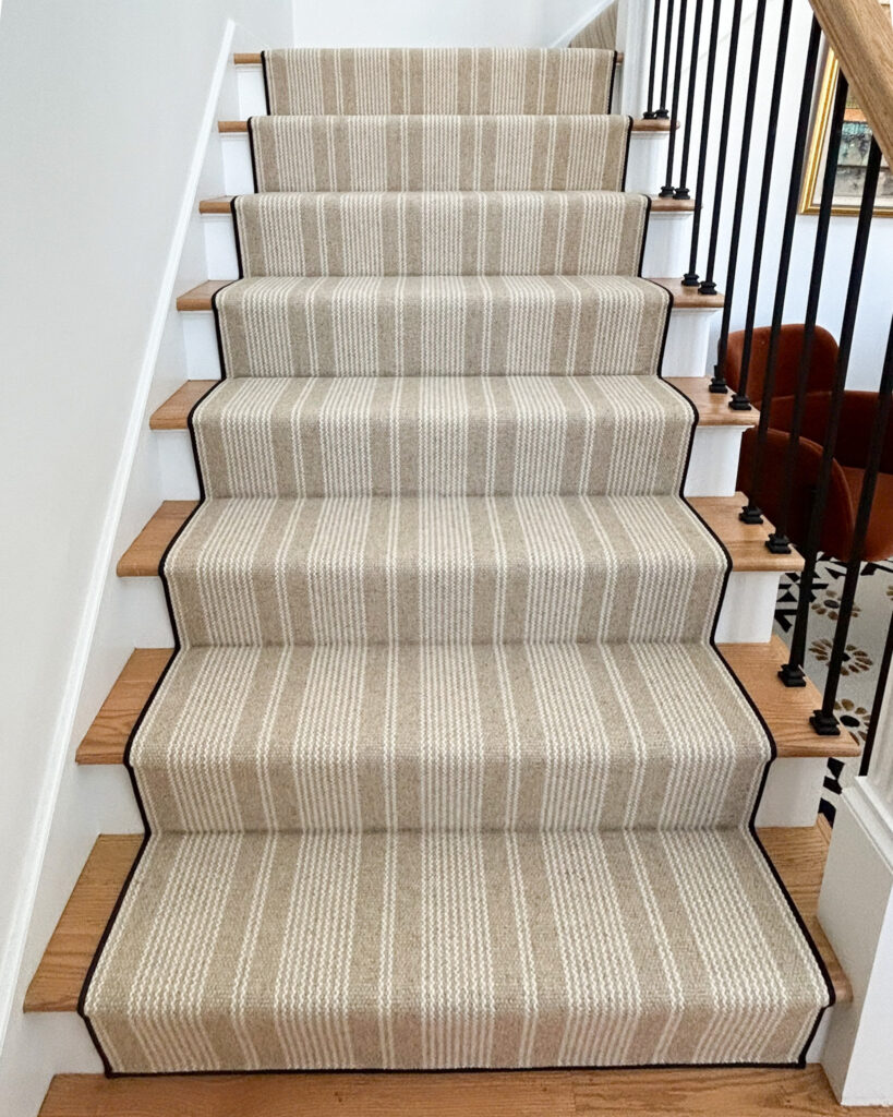 warm neutral striped stair runner with waterfall install method.
