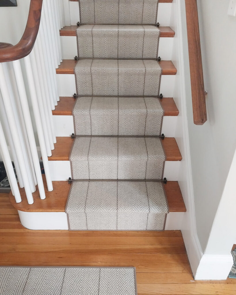 Neutral stair runner with herringbone pattern and waterfall style installation.