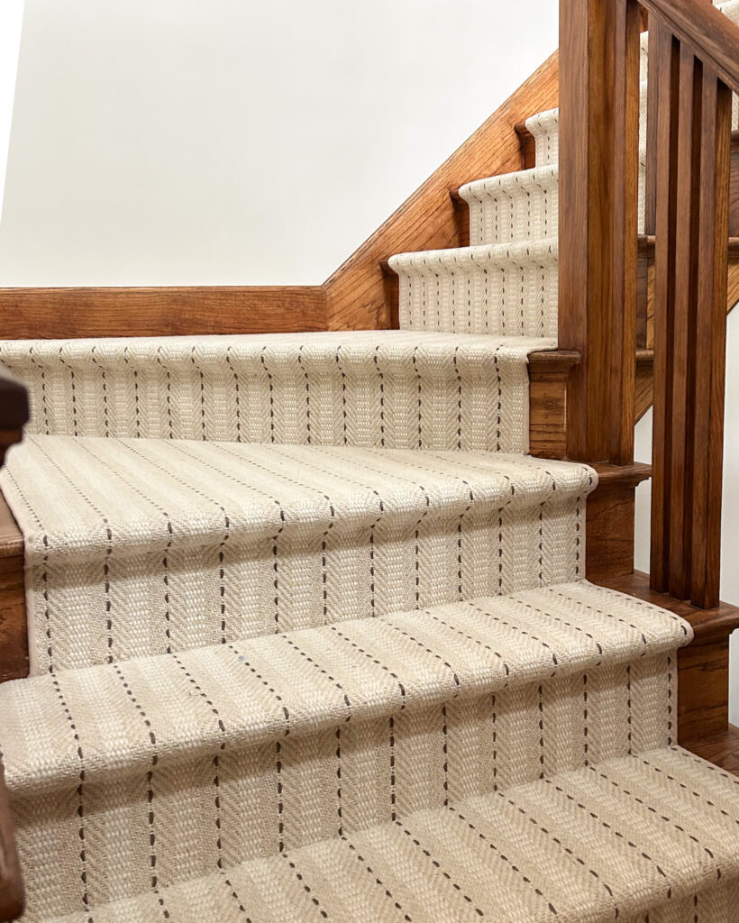 Warm neutral stair runner with striped pattern and Hollywood style install