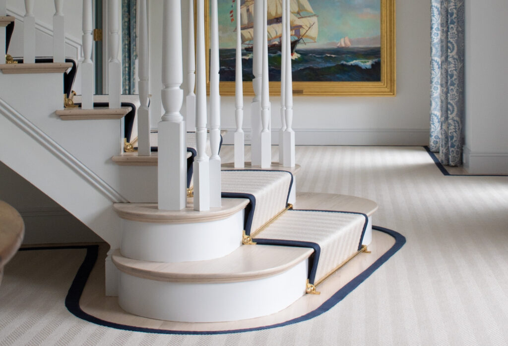 Luxurious Cape home decorated with custom cut stair runner on bridal stairs and custom cut rug for entry and main area. Finished with wide binding. Installed using waterfall style.
