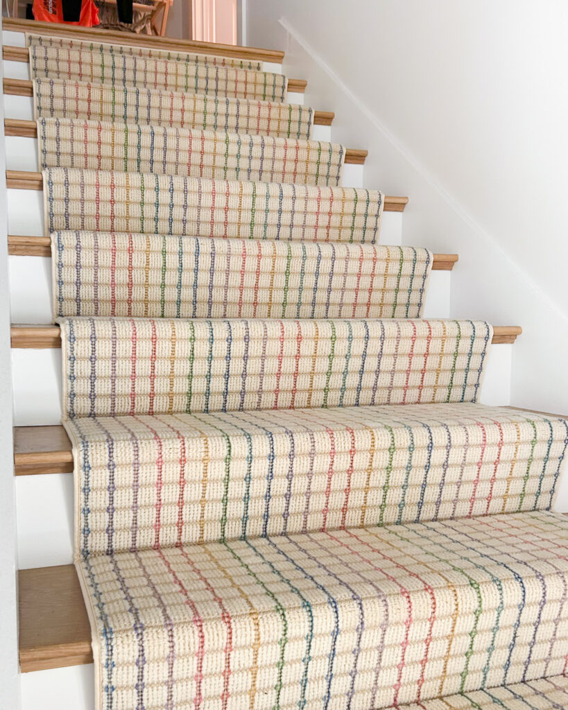 Colorful stair runner with rainbow grid pattern. Installed using waterfall style